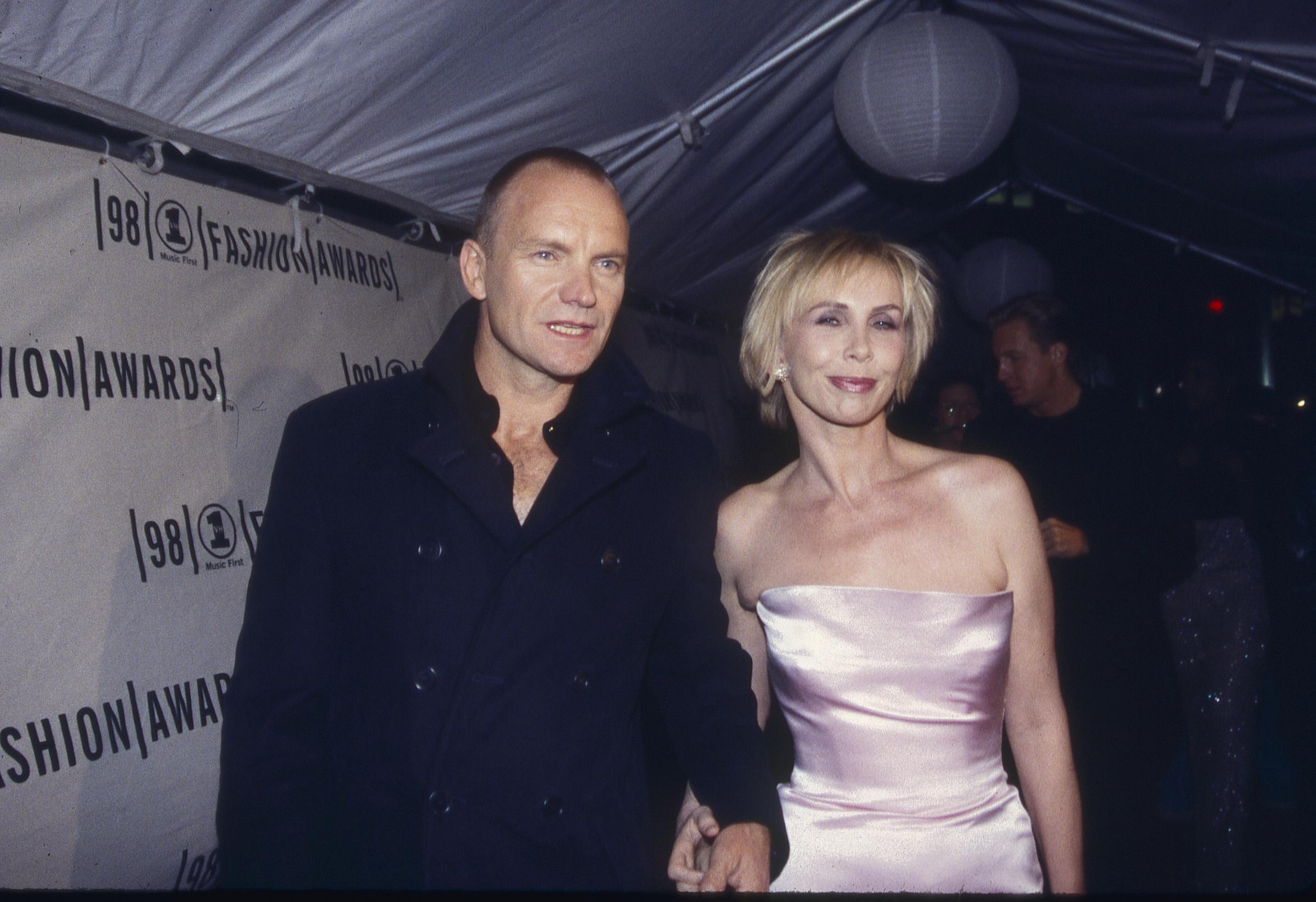 Trudie Styler wears a strapless, pale pink satin dress while posing alongside Sting at the 1998 VH1 Fashion Awards on October 12, 1998, in New York.