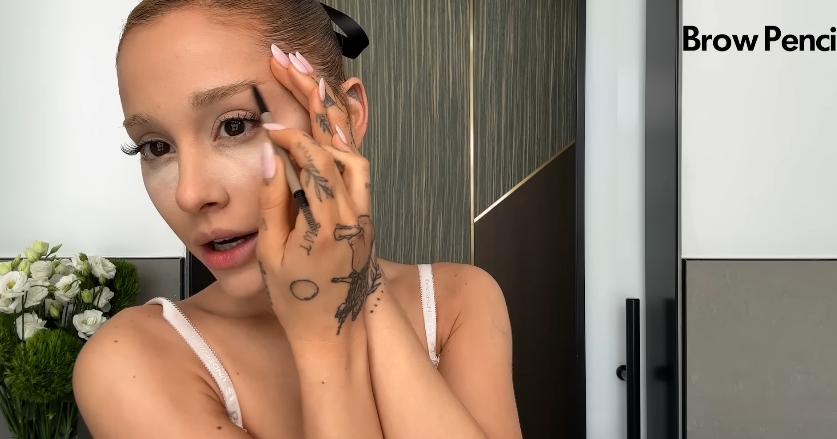 Ariana Grande doing her beauty routine from a post dated September 12, 2023. | Source: YouTube\Vogue