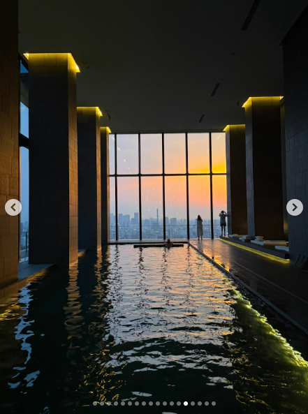 A view of a pool illuminated by a sunset as Tom Brady watches the view from the water and Vivian and Benjamin Brady look on from outside the pool. | Source: Instagram/tombrady