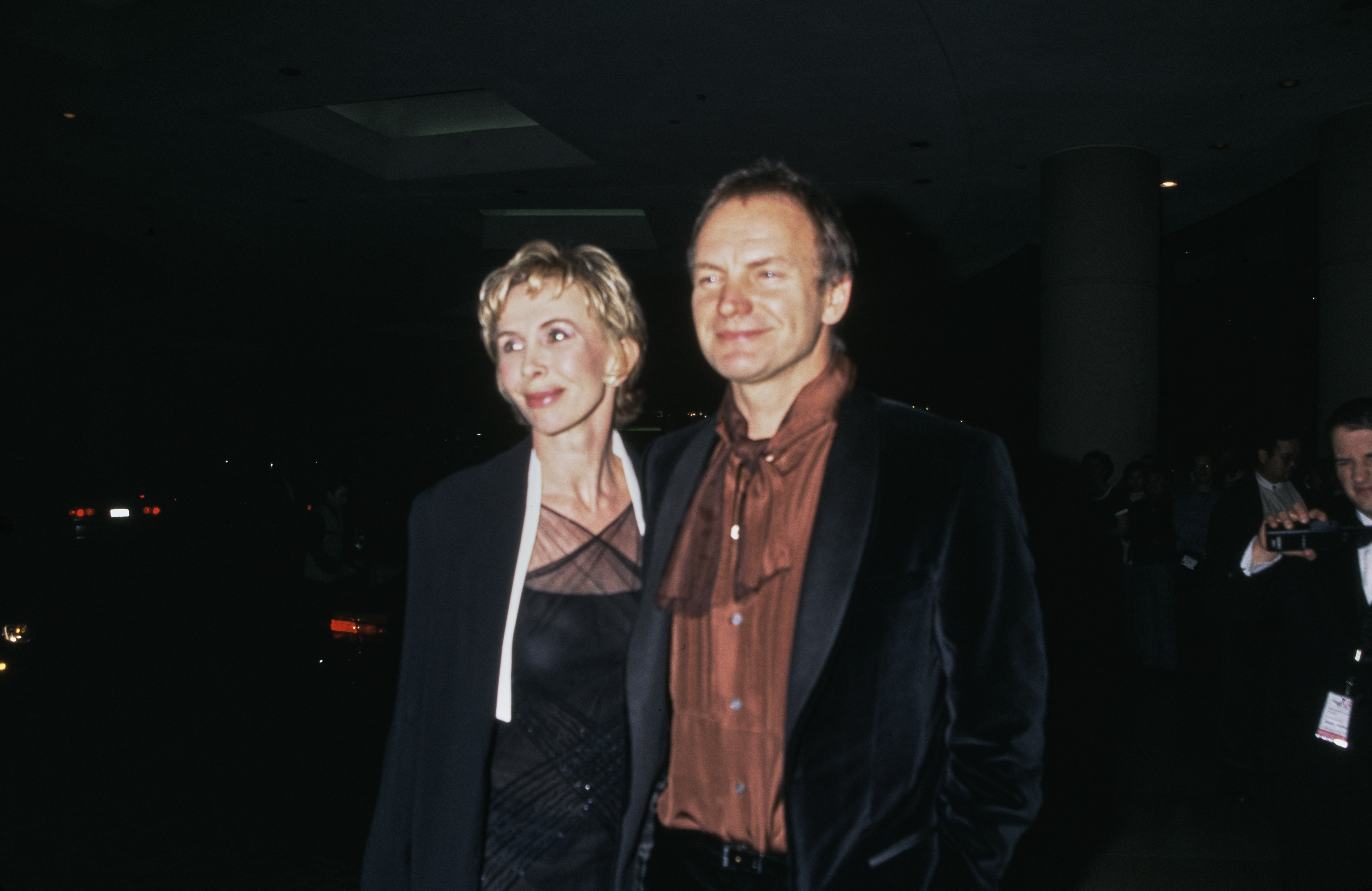 Trudie Styler wears a black dress with a sheer, crisscross neckline and a black blazer while attending the American Film Institute's Tribute to Dustin Hoffman in Los Angeles, California, on February 18, 1999.