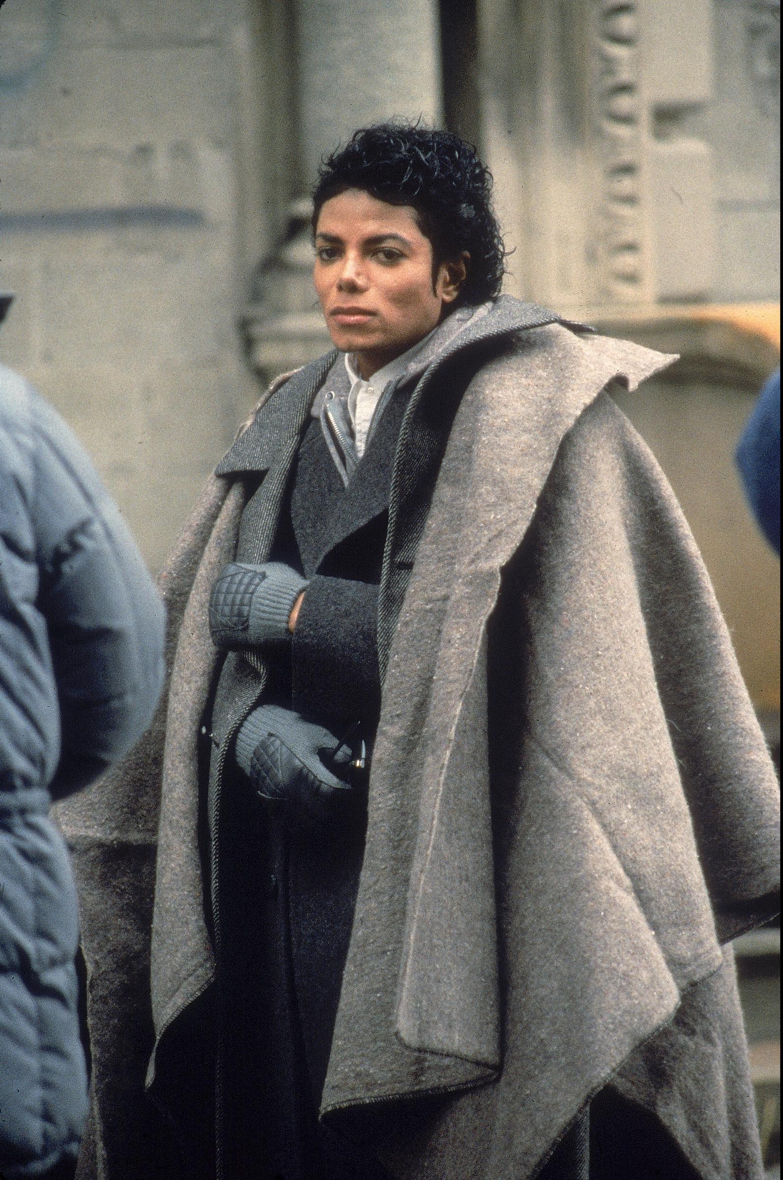 Michael Jackson bundles up in a layered gray coat and matching gloves. | Source: Getty Images